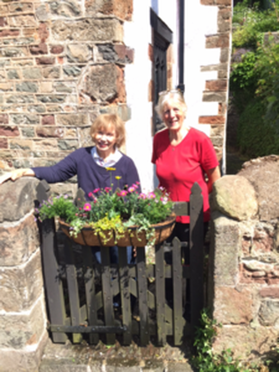 Dr Lita Strampp and Kath Trask preparing a planter for the museum gate as part of a village enhancement project.